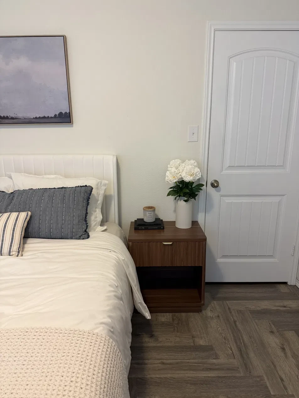 Staged bedroom with nightstand, linens and decor ready for the next guest