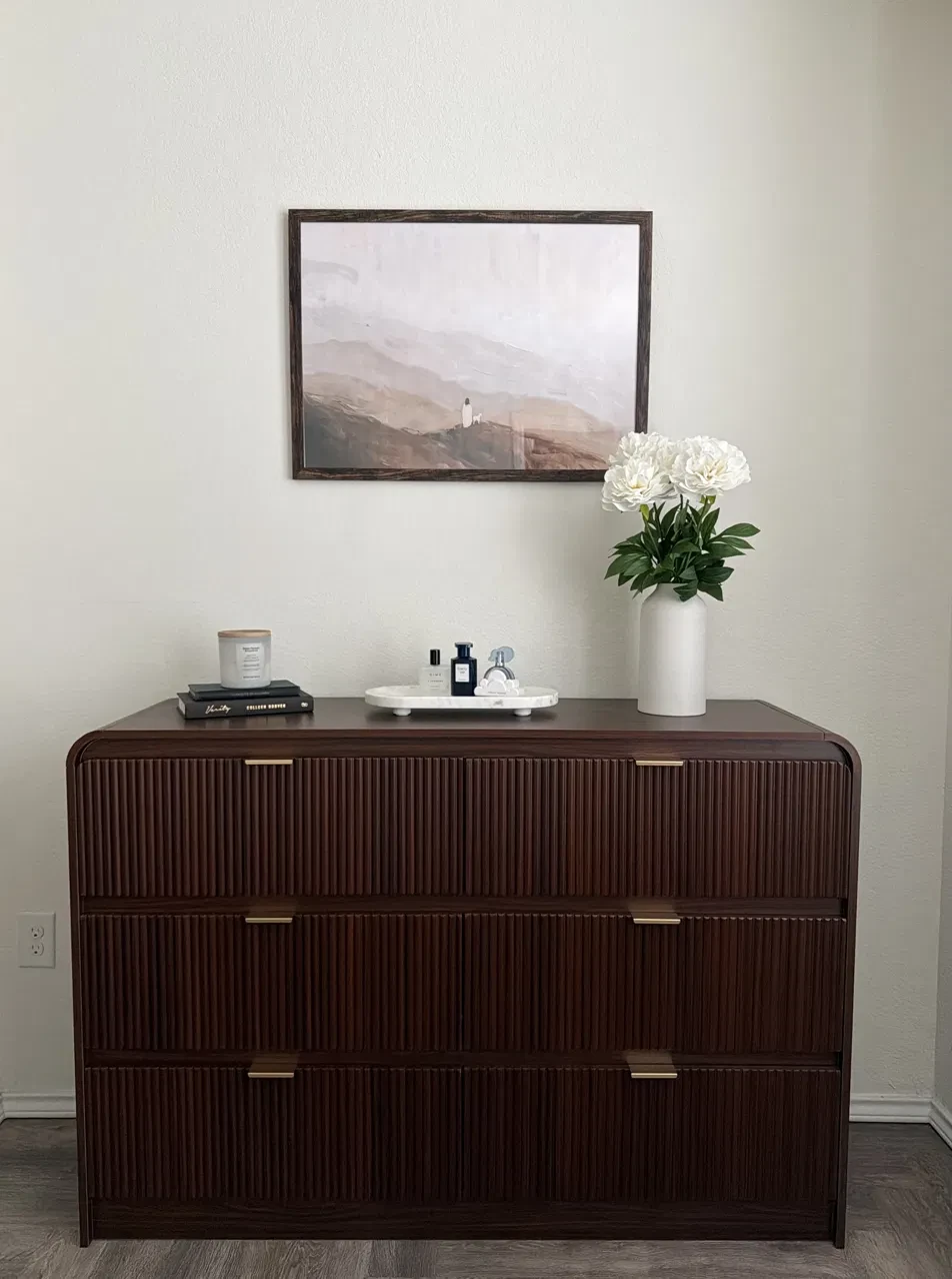Styled bedroom dresser with framed art and fresh florals in a turned rental